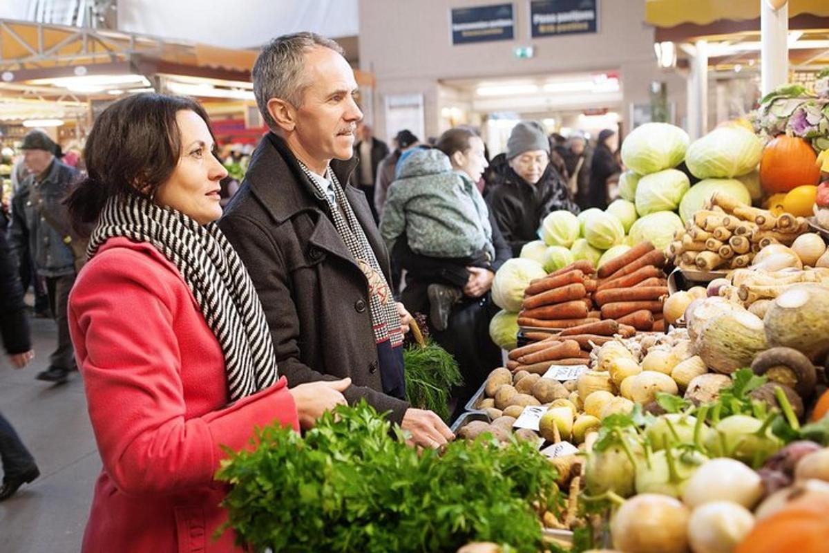 un uomo e una donna in piedi in un mercato ortofrutticolo