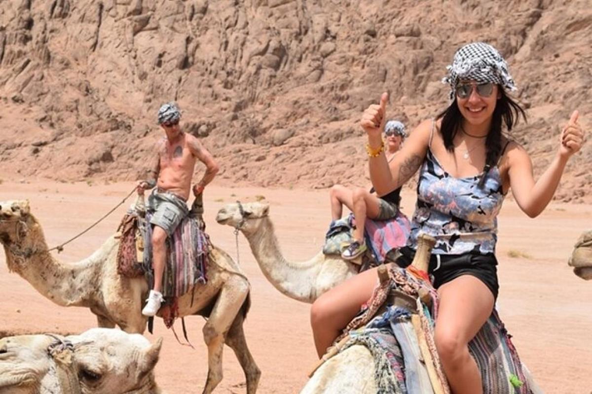مجموعة من الناس يركبون الجمال في الصحراء