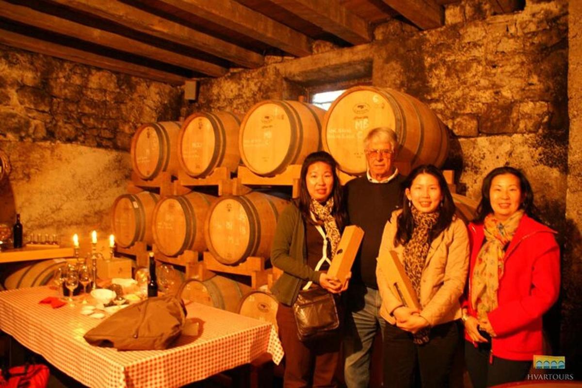 a group of people standing in a wine cellar