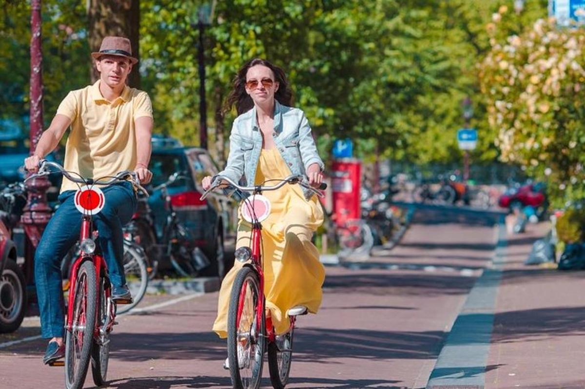 Un hombre y una mujer andan en bicicleta por una calle