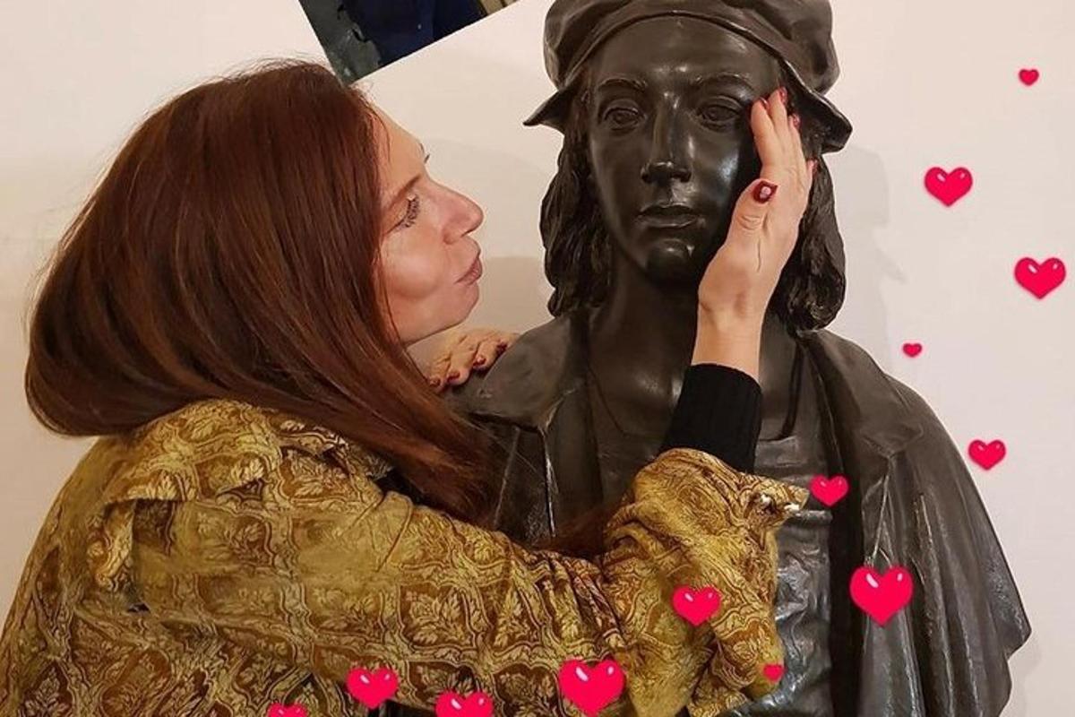 μια γυναίκα που στέκεται δίπλα σε ένα άγαλμα ενός άνδρα