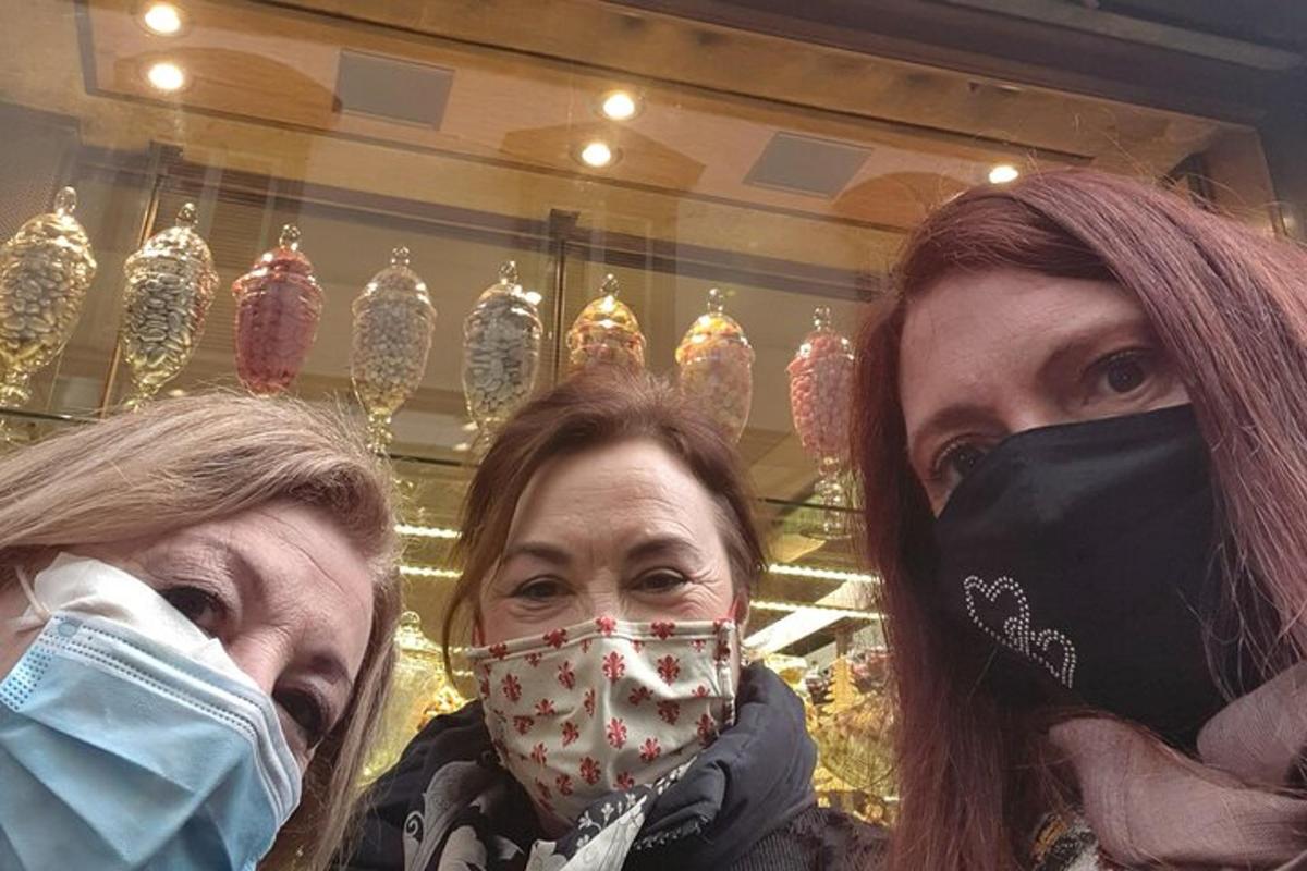 două femei purtând măști în fața unui magazin