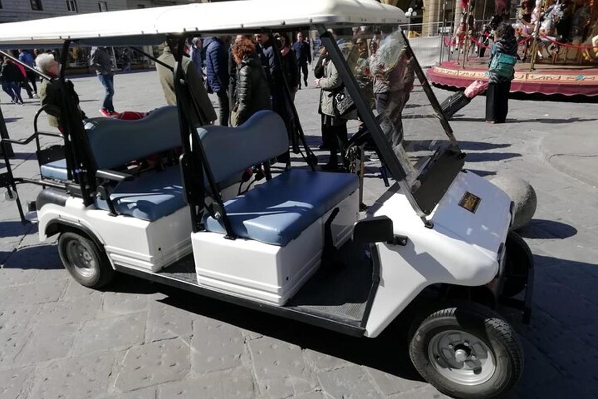 ένα αμαξίδιο γκολφ με δύο καθίσματα και άτομα