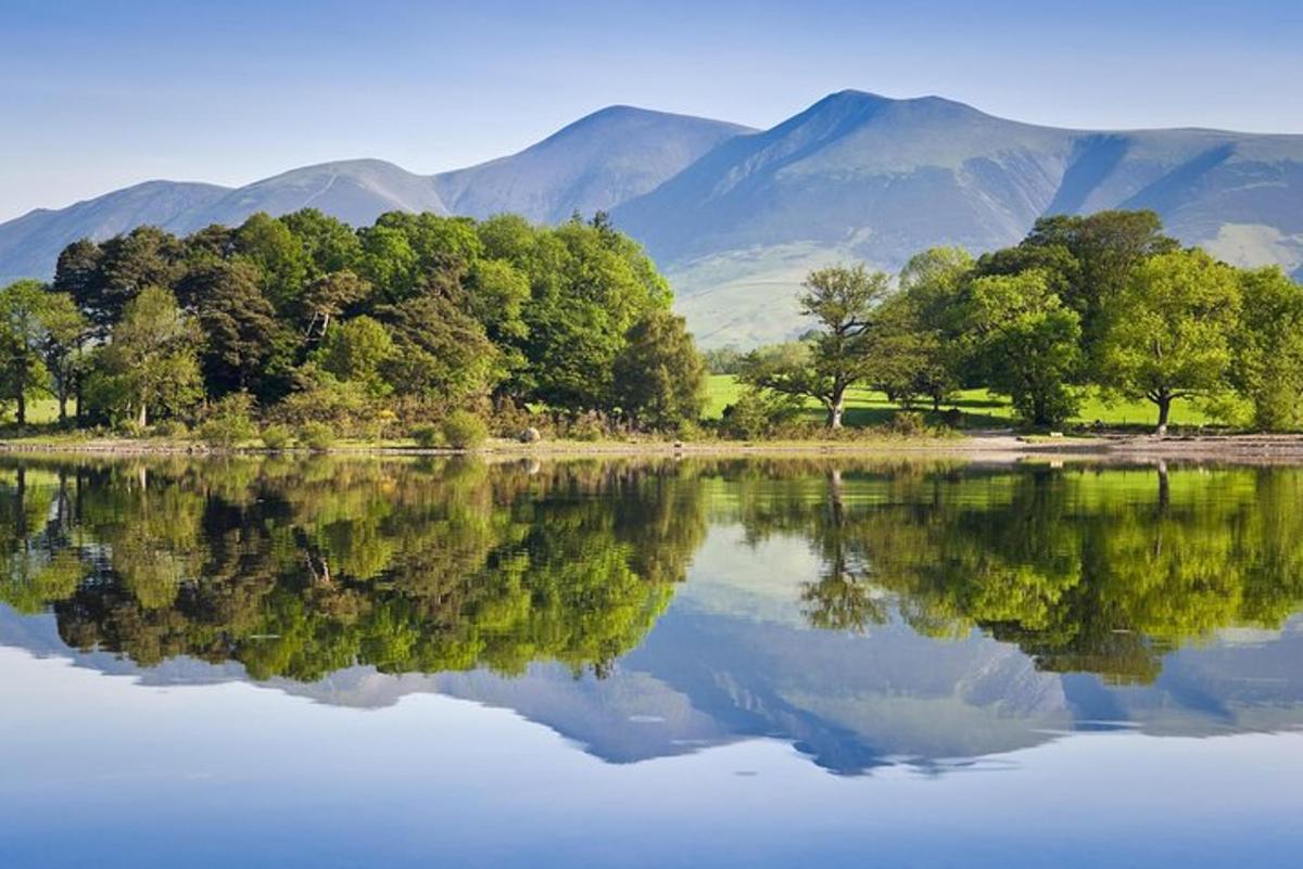 uno specchio d'acqua con alberi e montagne sullo sfondo