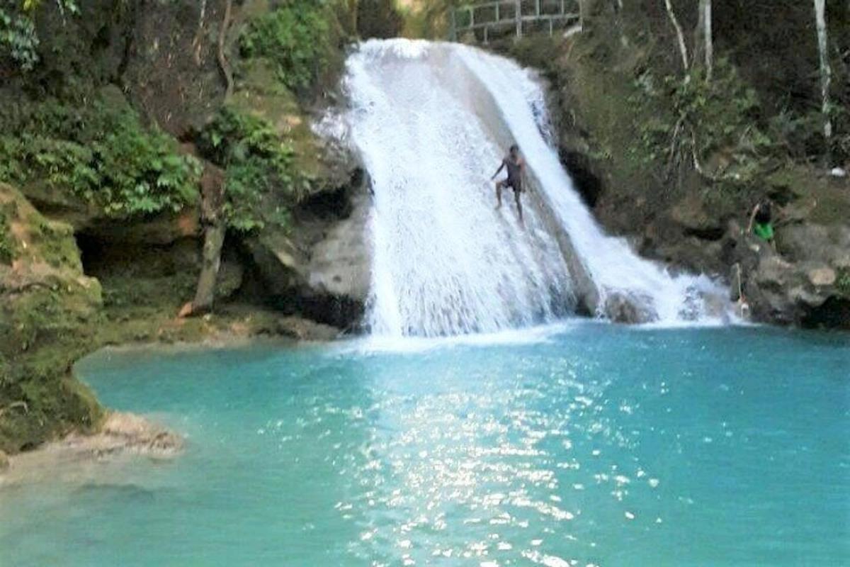 un uomo in piedi in cima a una cascata