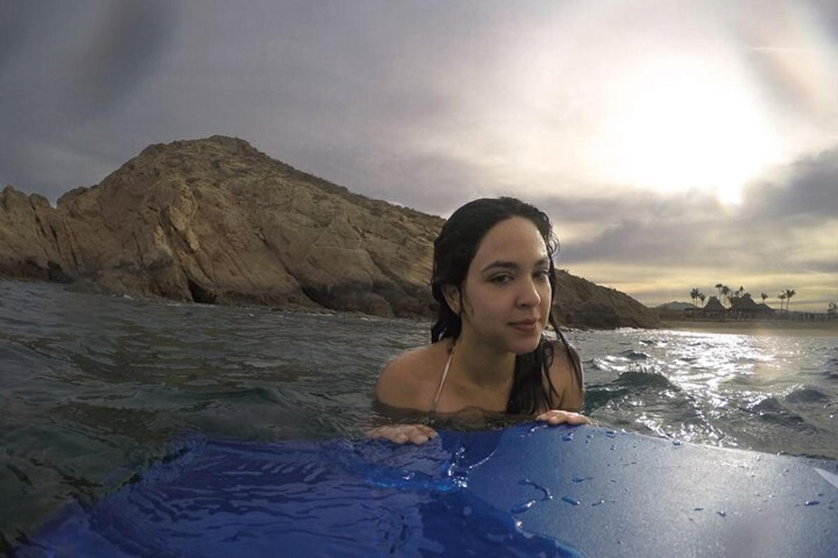 una donna seduta su una tavola da surf in acqua