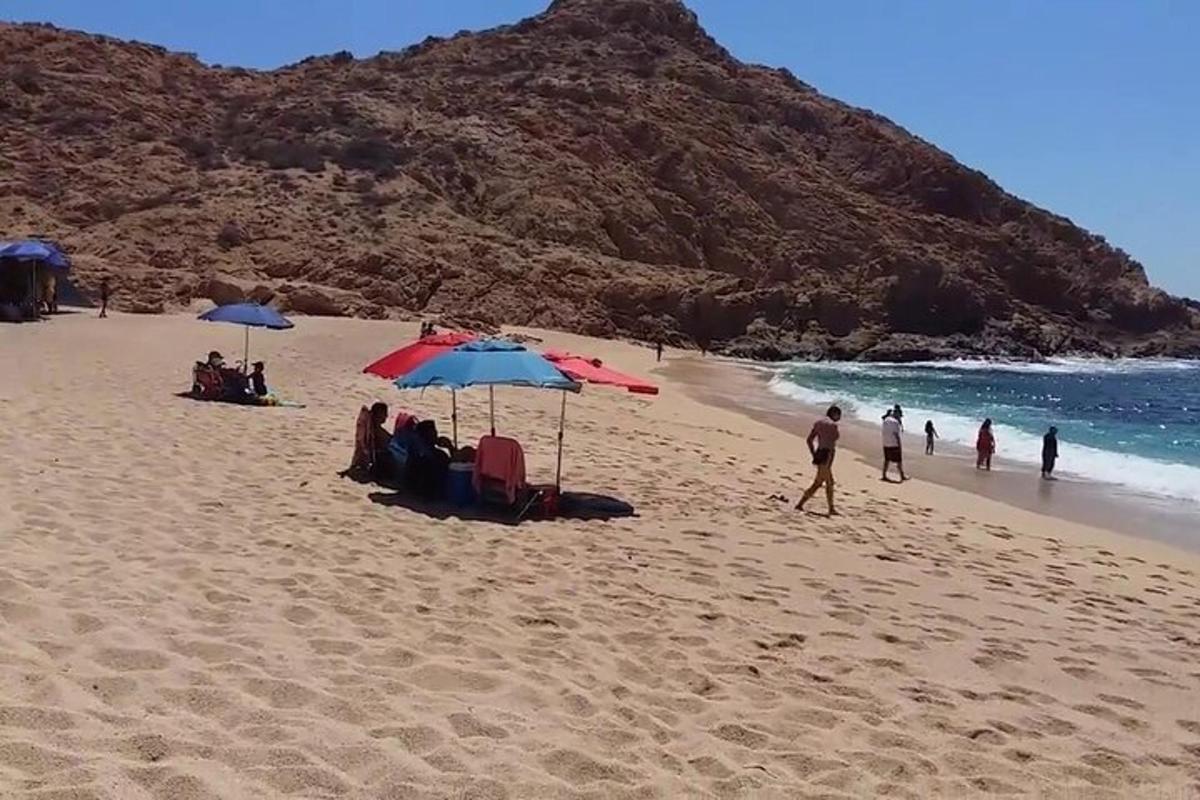 un gruppo di persone sedute su una spiaggia con gli ombrelloni