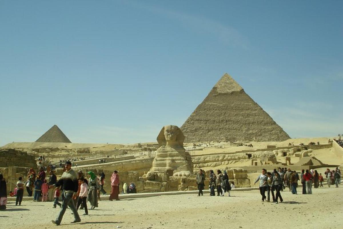 skupina lidí procházejících se před pyramidami