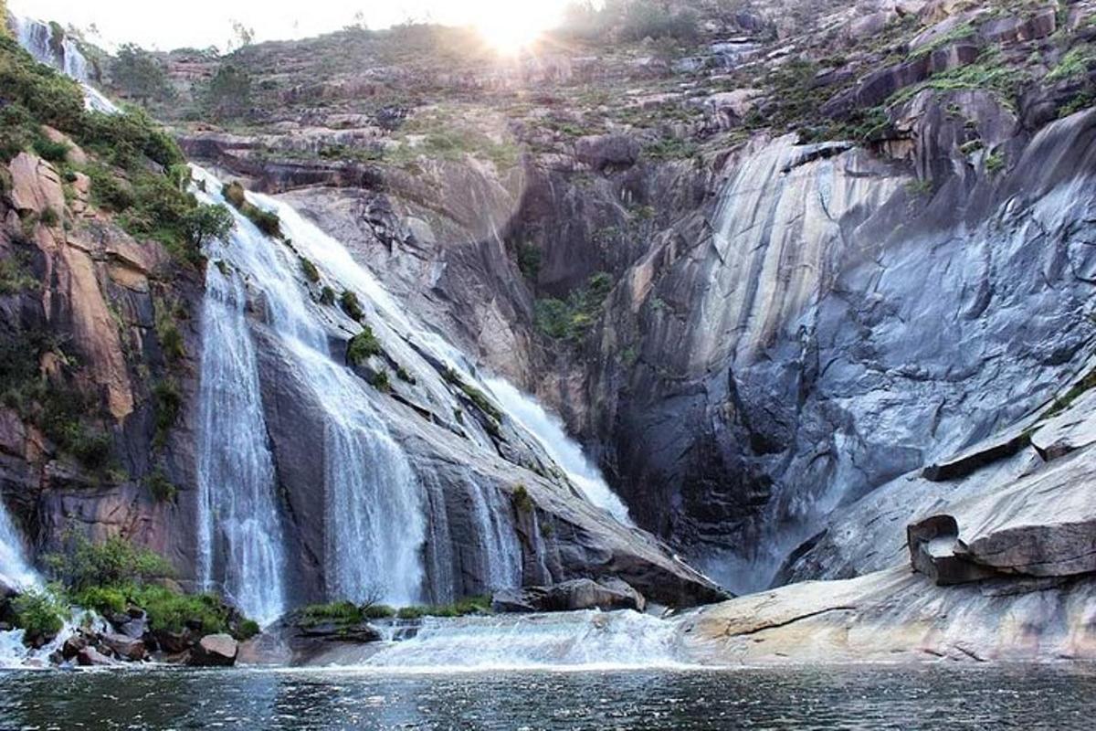 una cascata in un canyon con uno specchio d'acqua