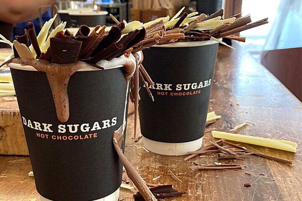 a couple of black cups with chocolate on a counter