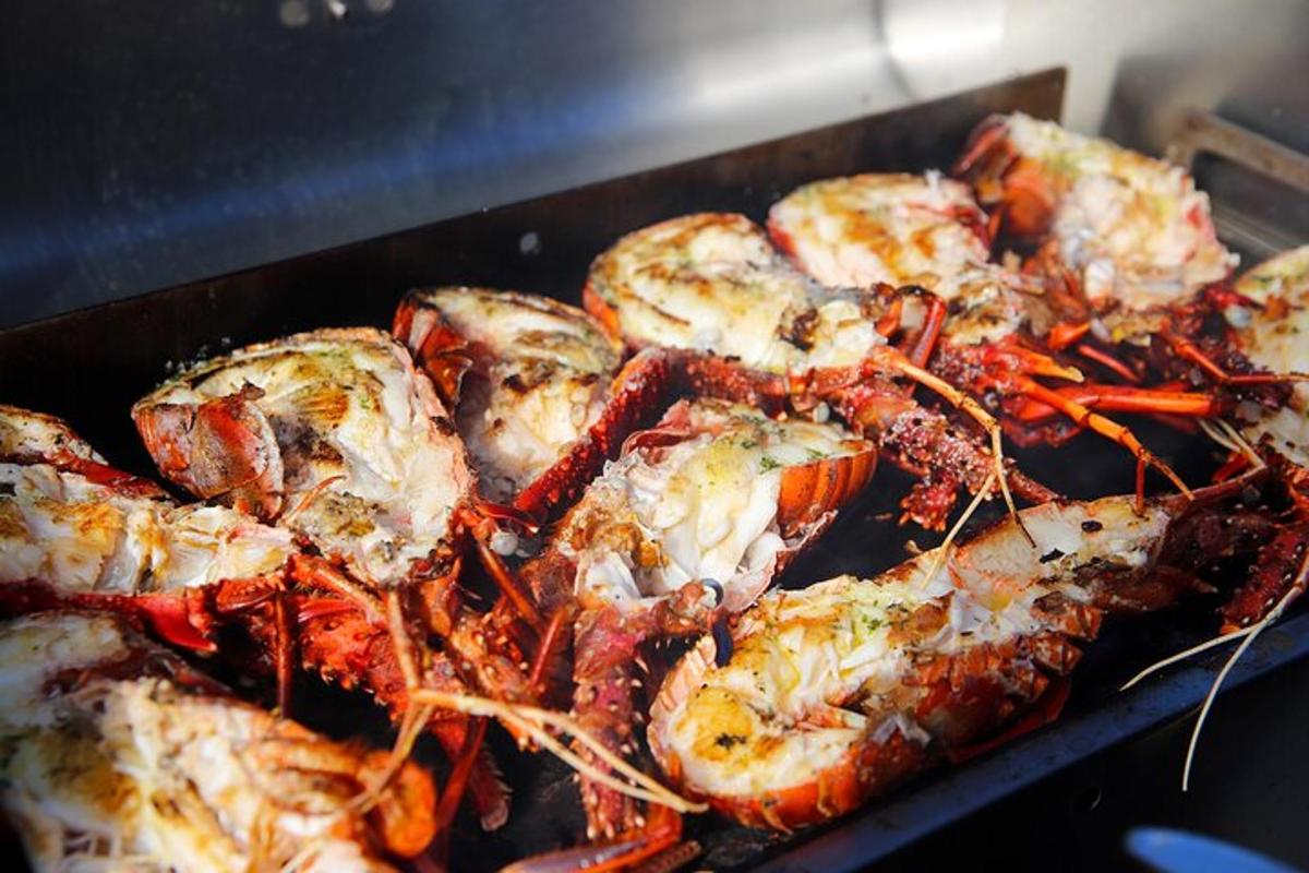Un montón de camarones se están cocinando en una parrilla