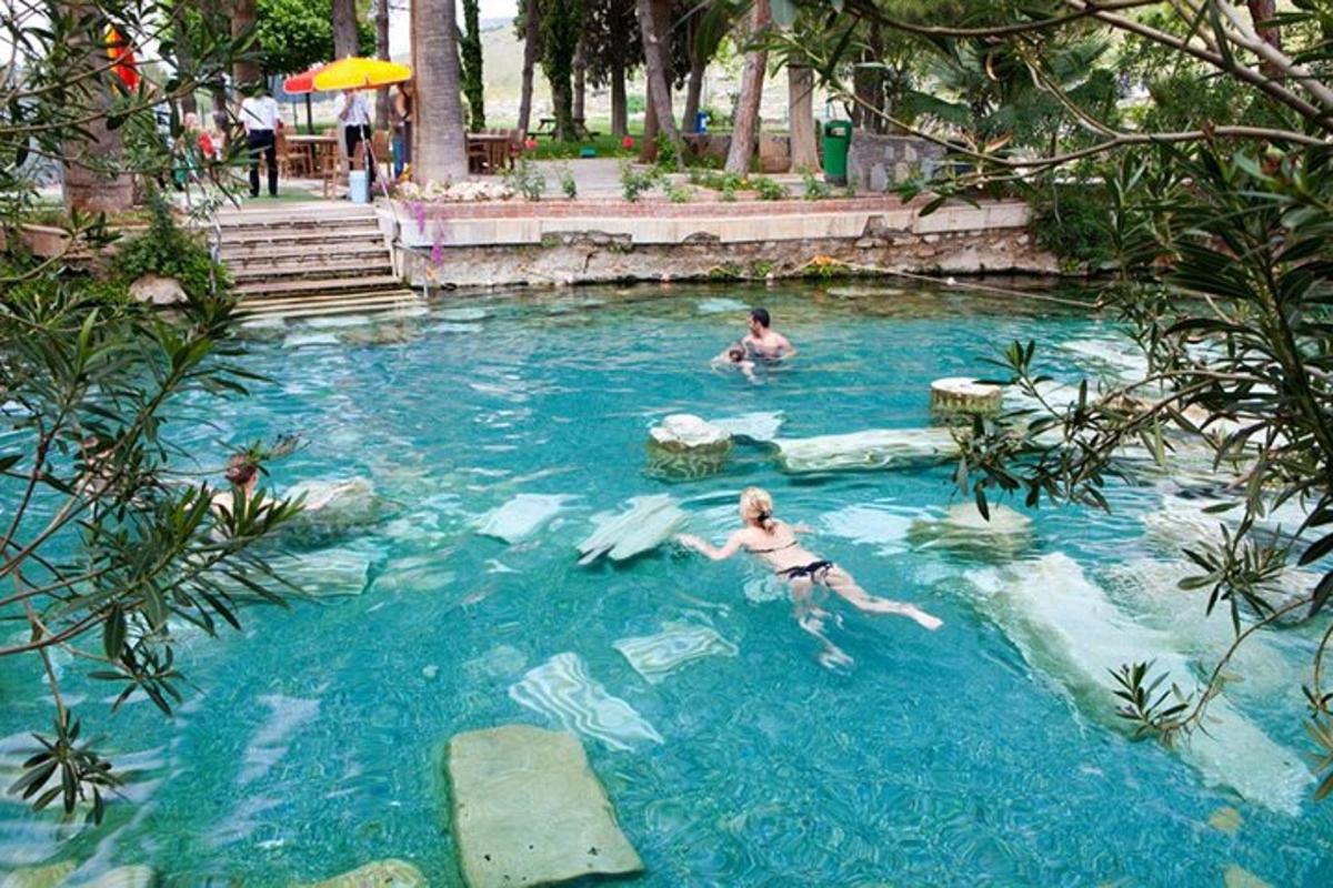 двоє людей плавають у басейні на курорті