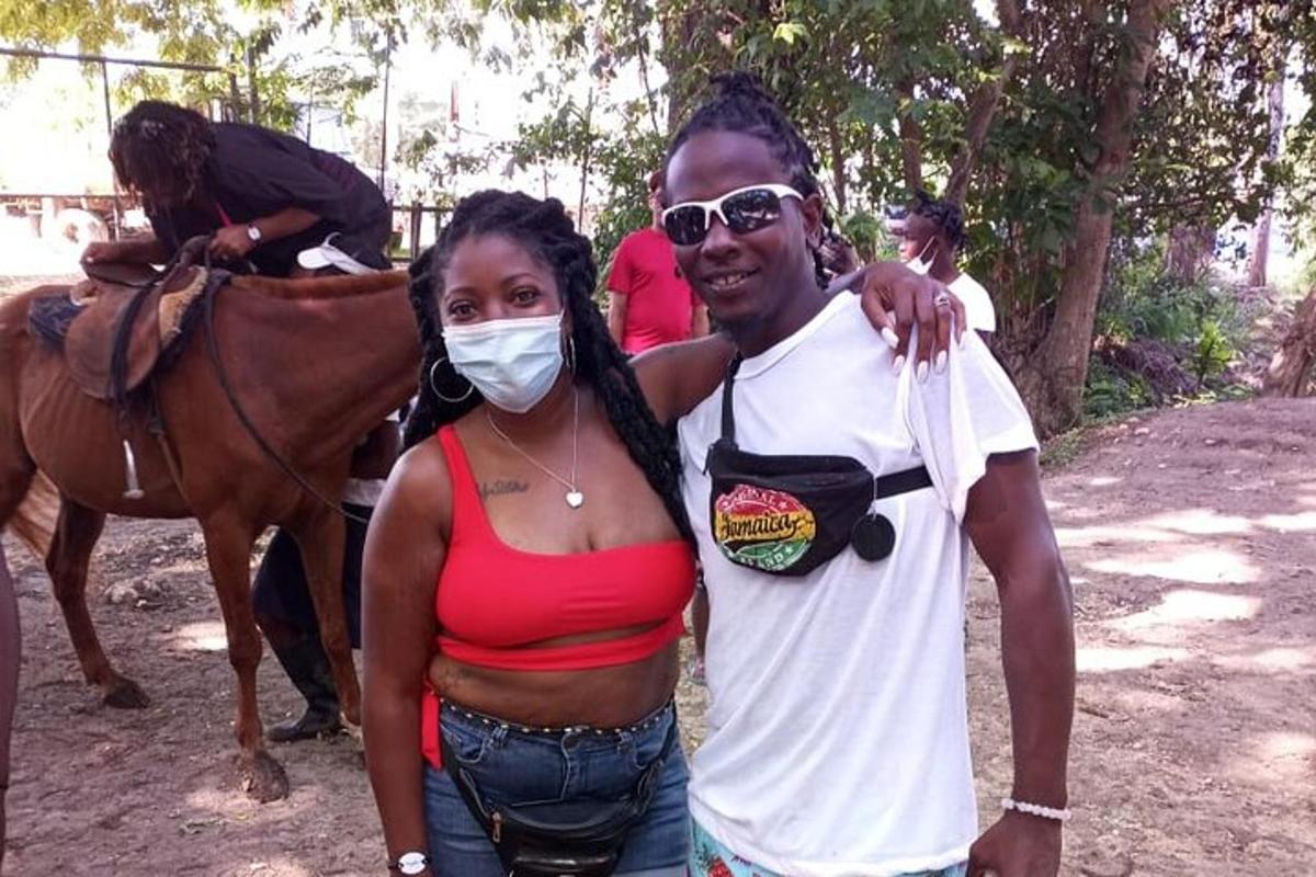 a man and a woman standing next to a horse