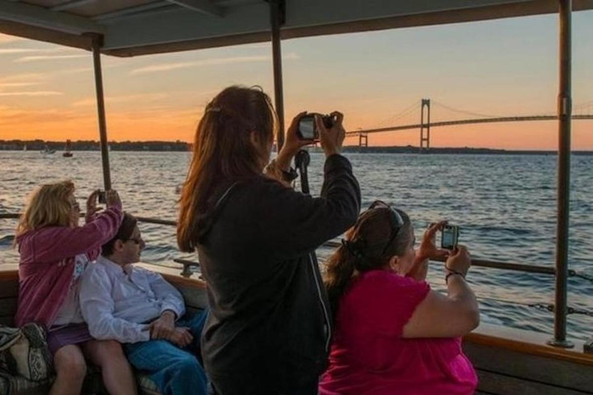 a group of people on a boat taking pictures of the golden gate bridge