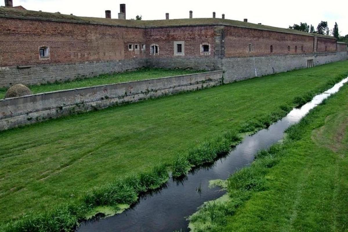 Un río frente a un gran edificio de ladrillos.