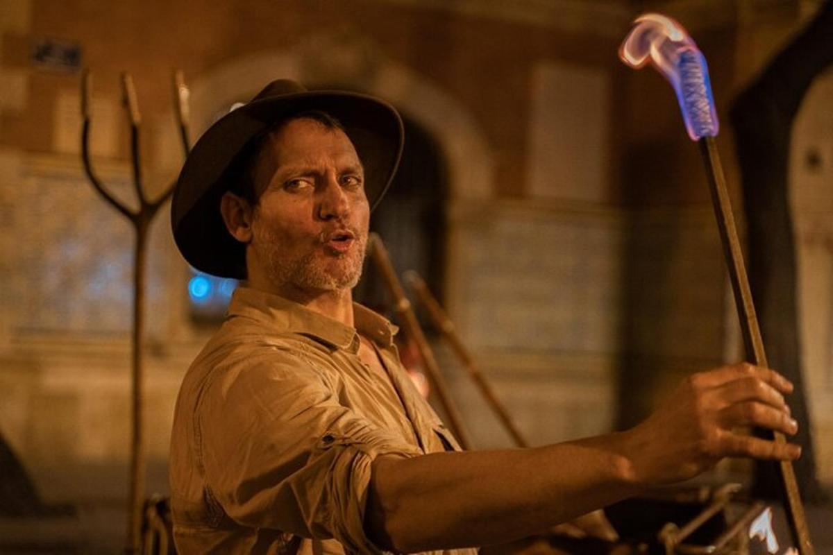 a man wearing a cowboy hat holding a stick