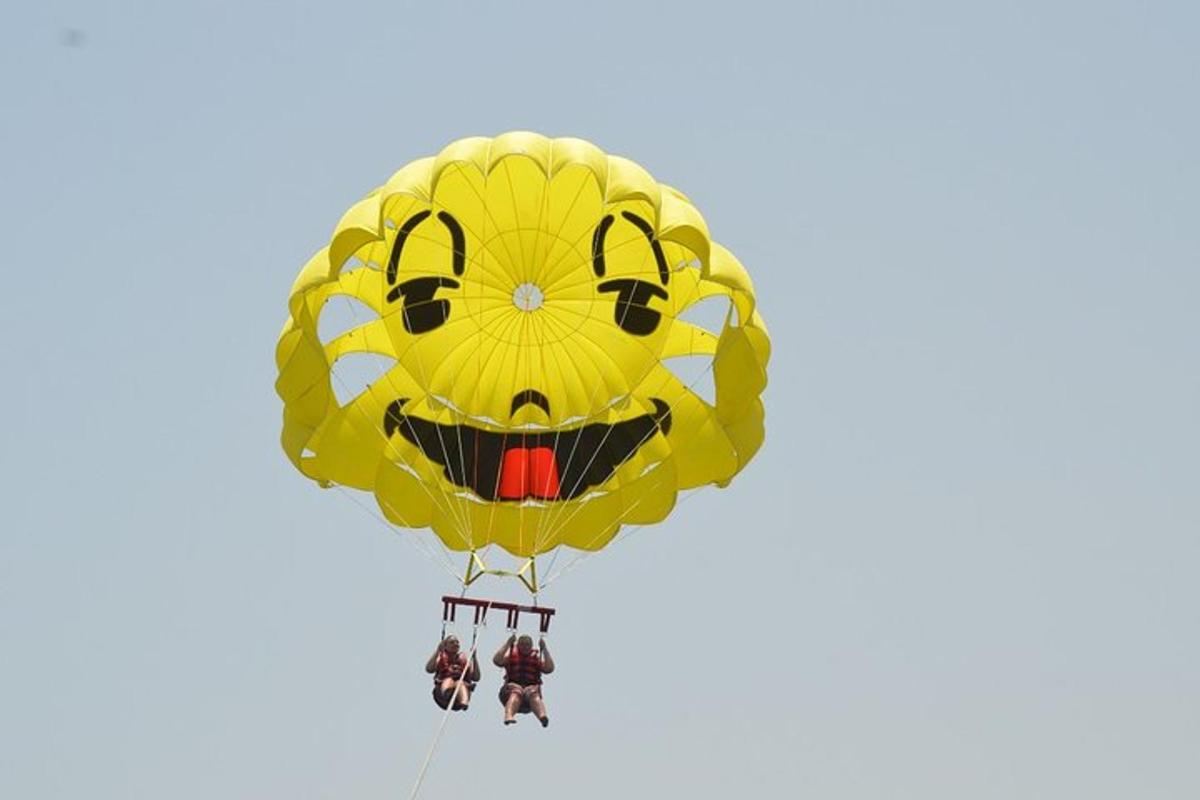 un grande aquilone giallo con una faccina sorridente che vola nel cielo