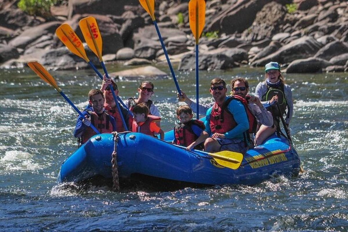 a group of people in a blue raft in the water