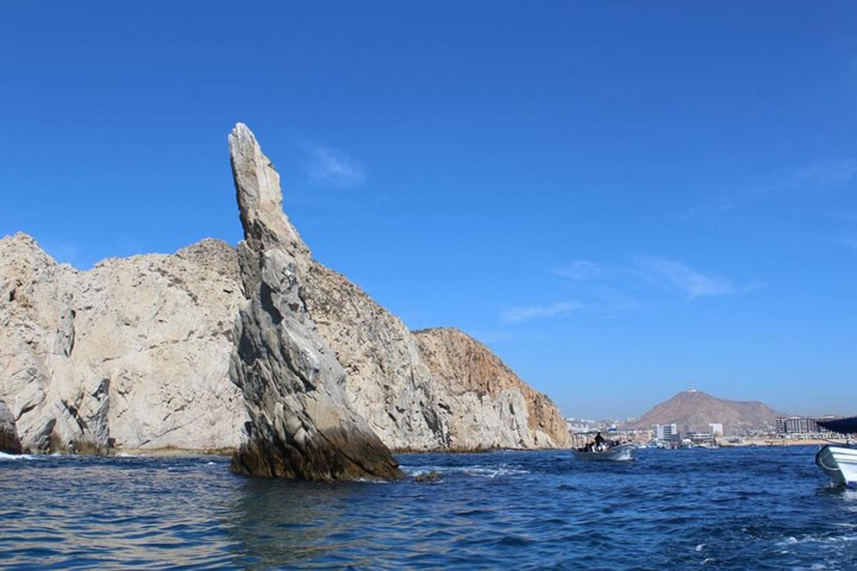 a rock formation in the water with a boat