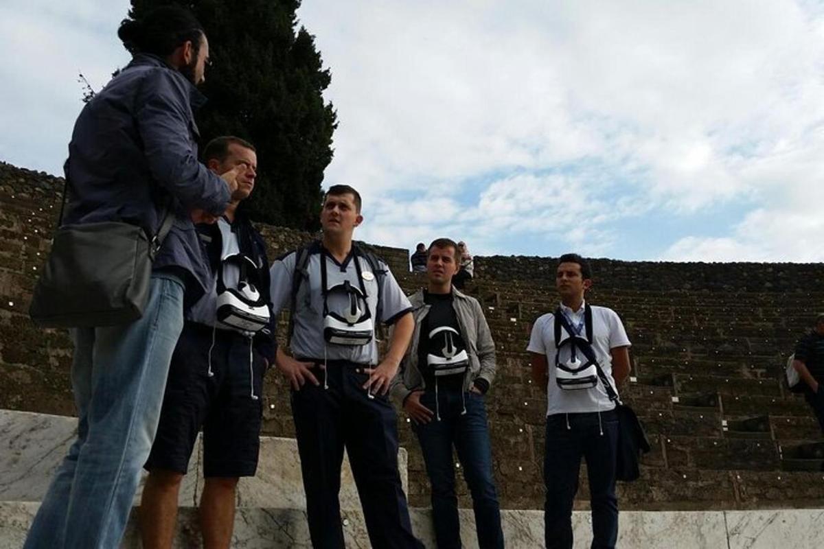 a group of men standing next to a brick wall