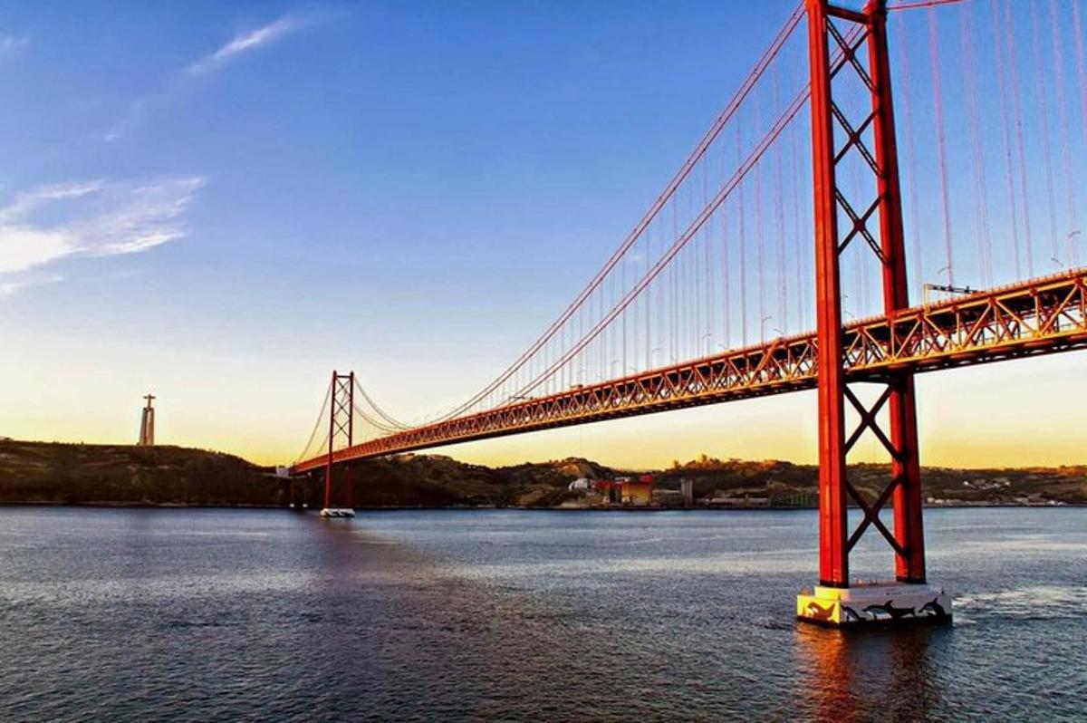 uma ponte sobre a água com um farol ao fundo