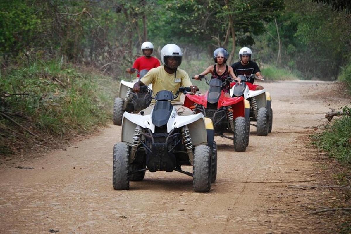 un grup de persones que condueixen quads per un camí de terra