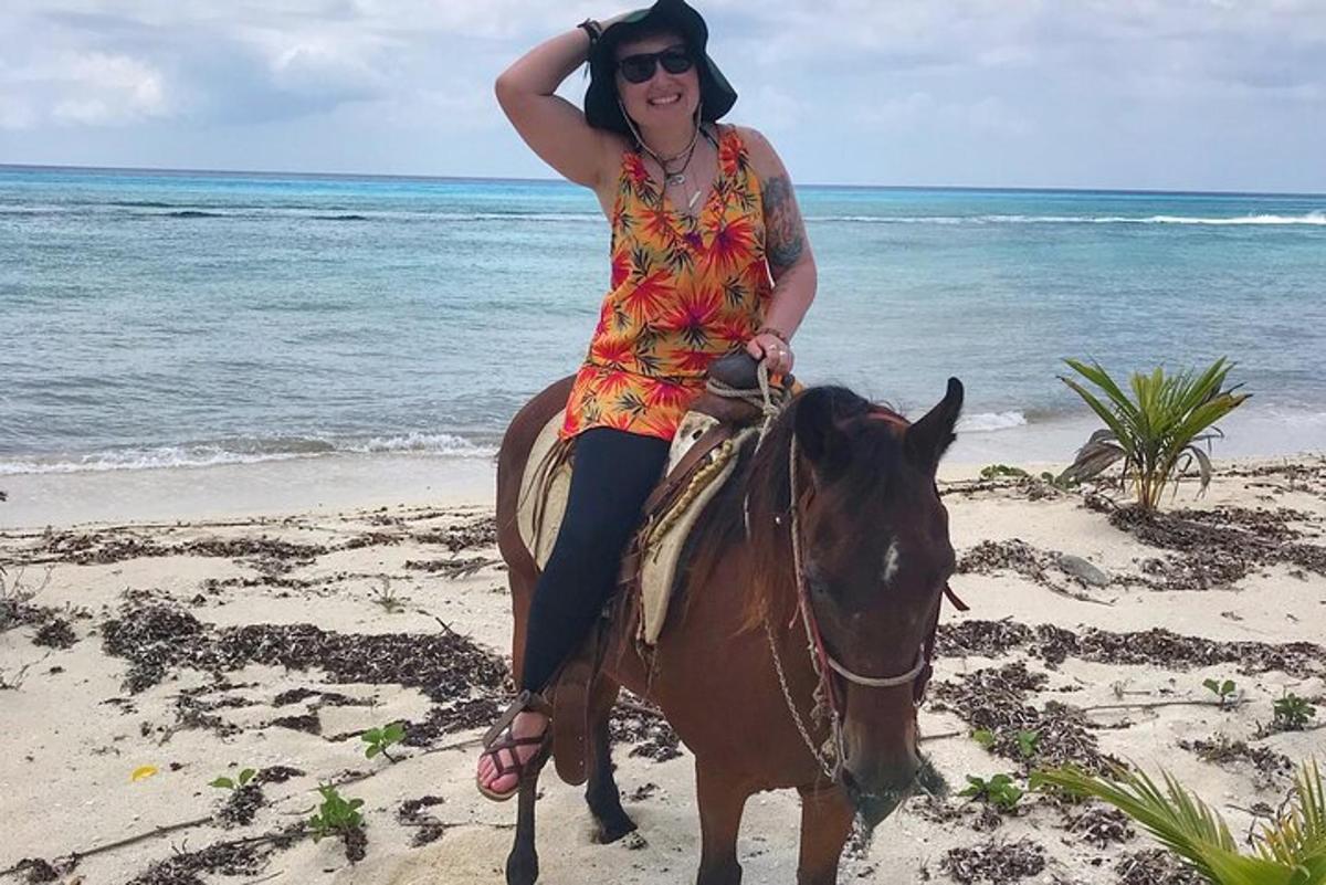 una donna a cavallo sulla spiaggia