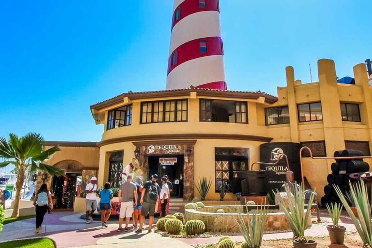 a group of people standing outside of a building with a lighthouse