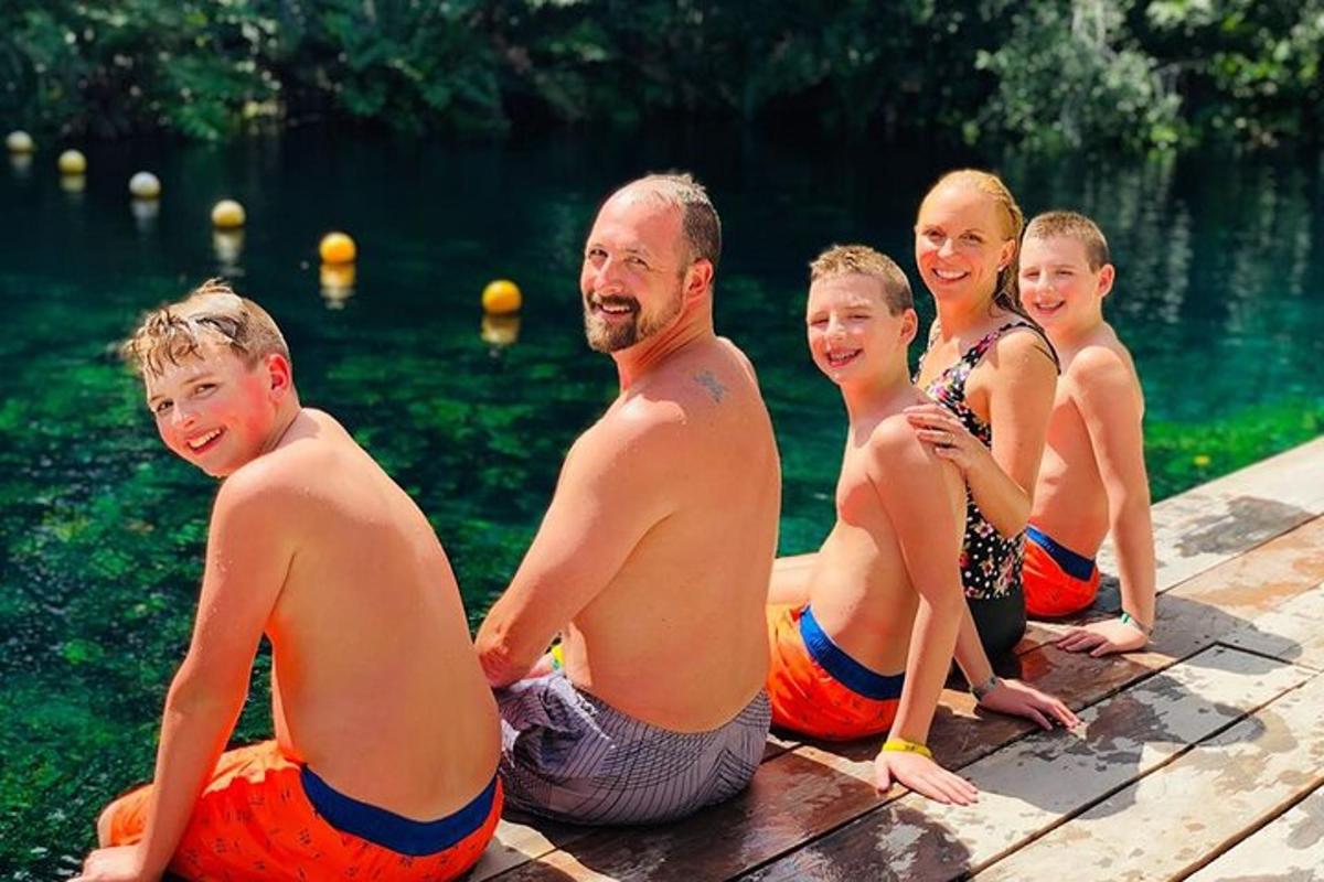 Un grupo de personas sentadas en un muelle en el agua.