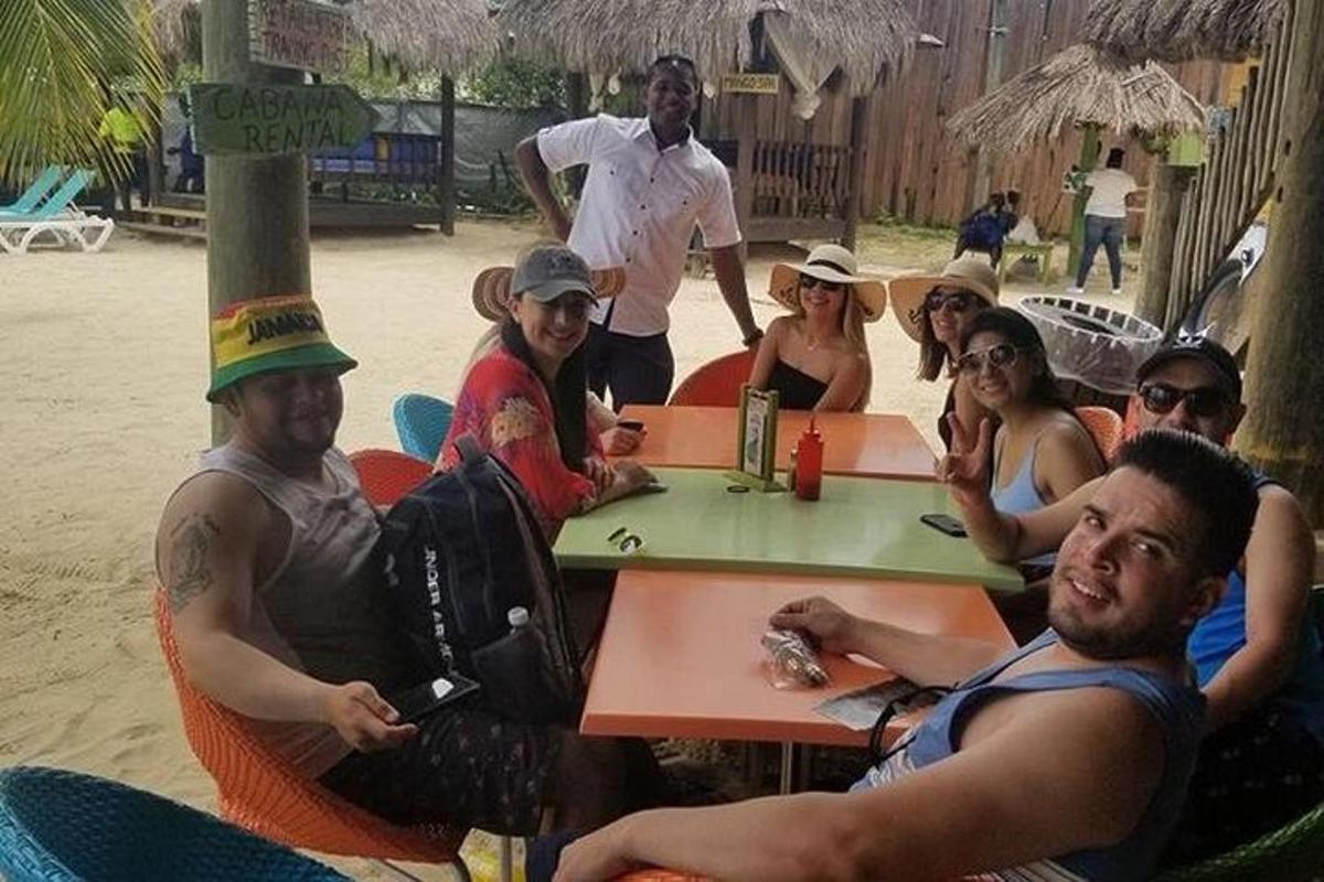 Un grupo de personas sentadas en una mesa en la playa.