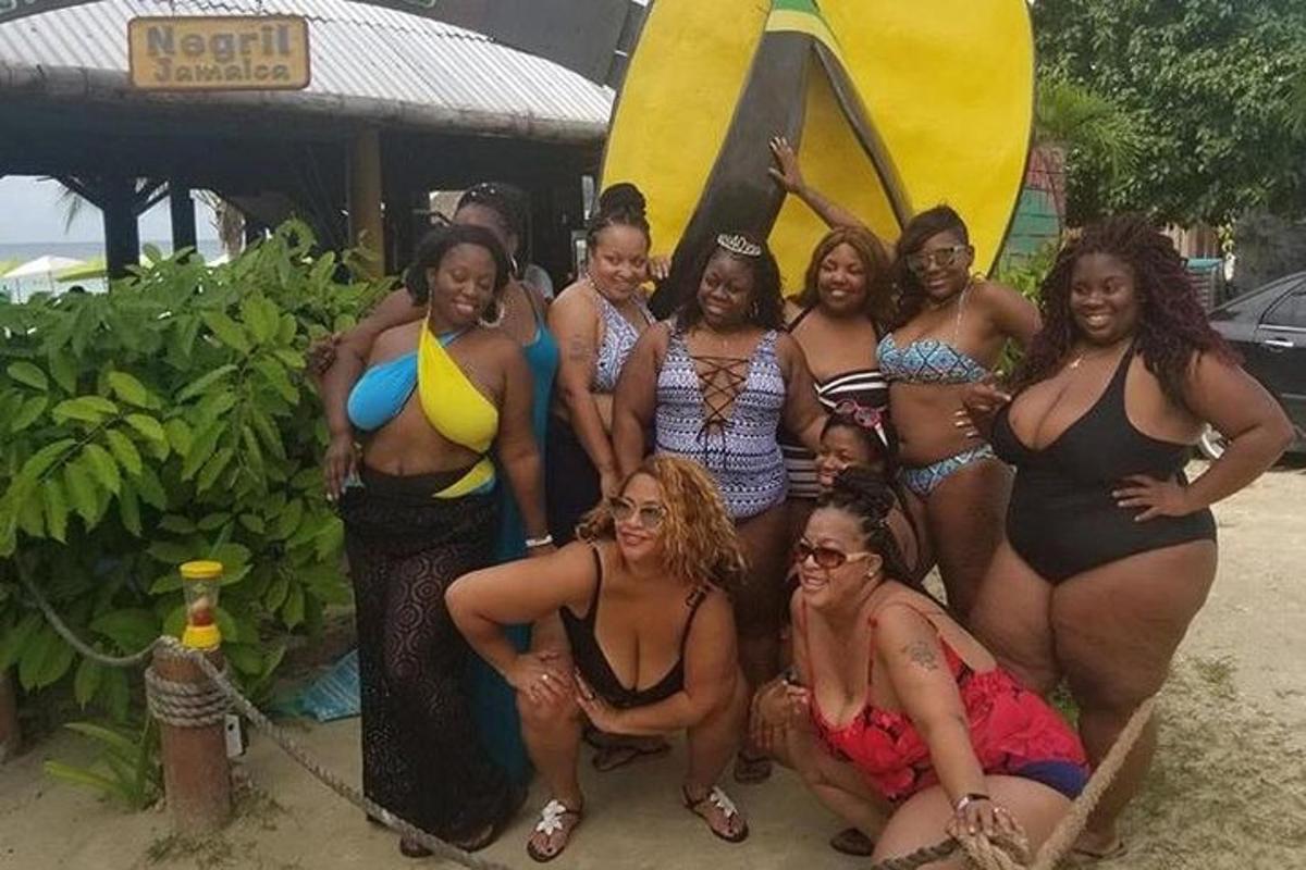 Un grupo de mujeres posando para una foto frente a una tabla de surf.
