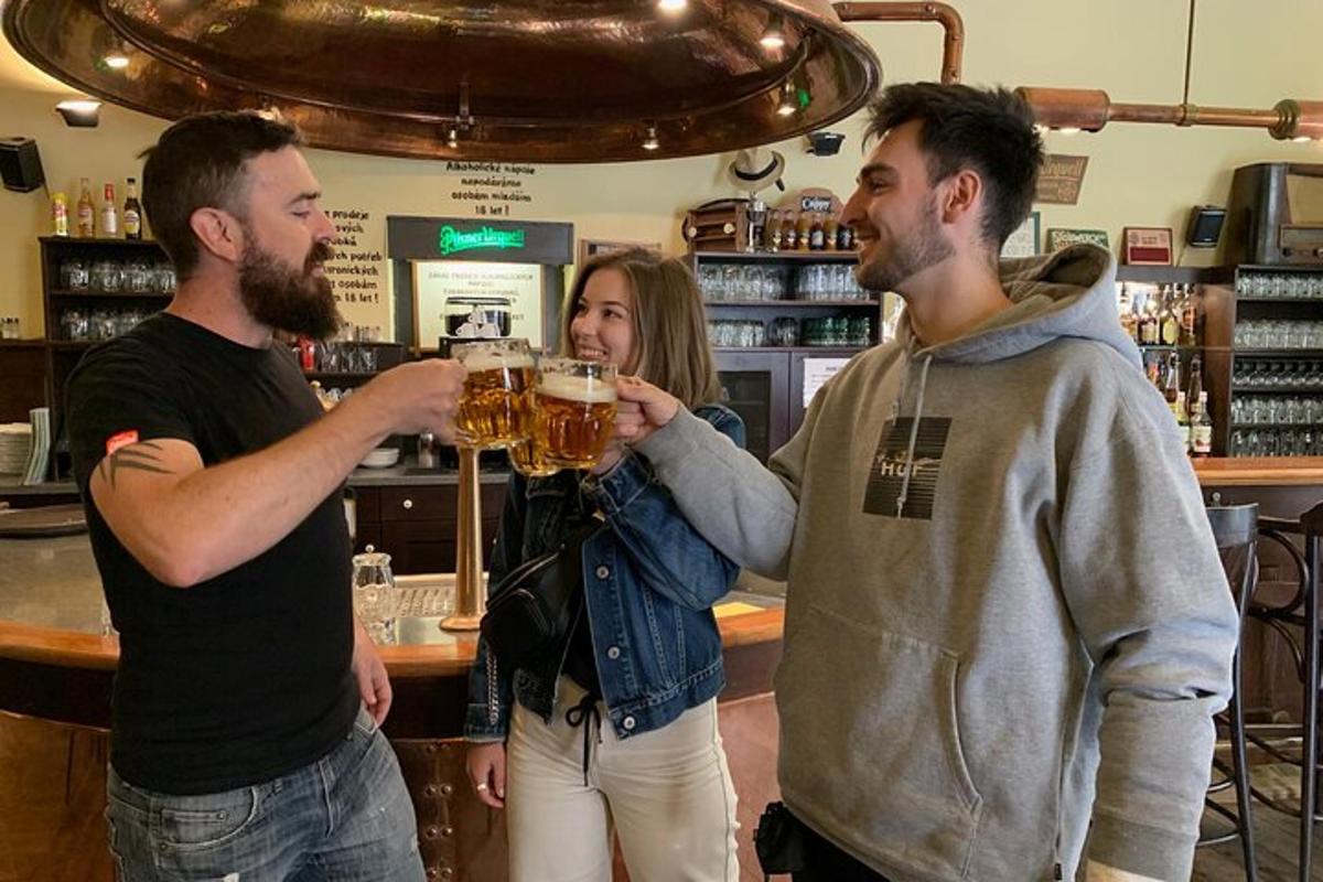 zwei Männer und eine Frau trinken Bier in einer Bar