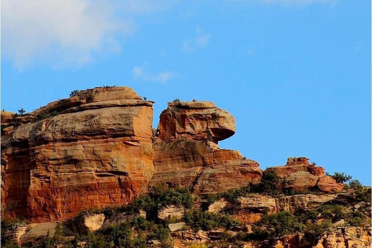Una montaña rocosa con un cielo azul al fondo