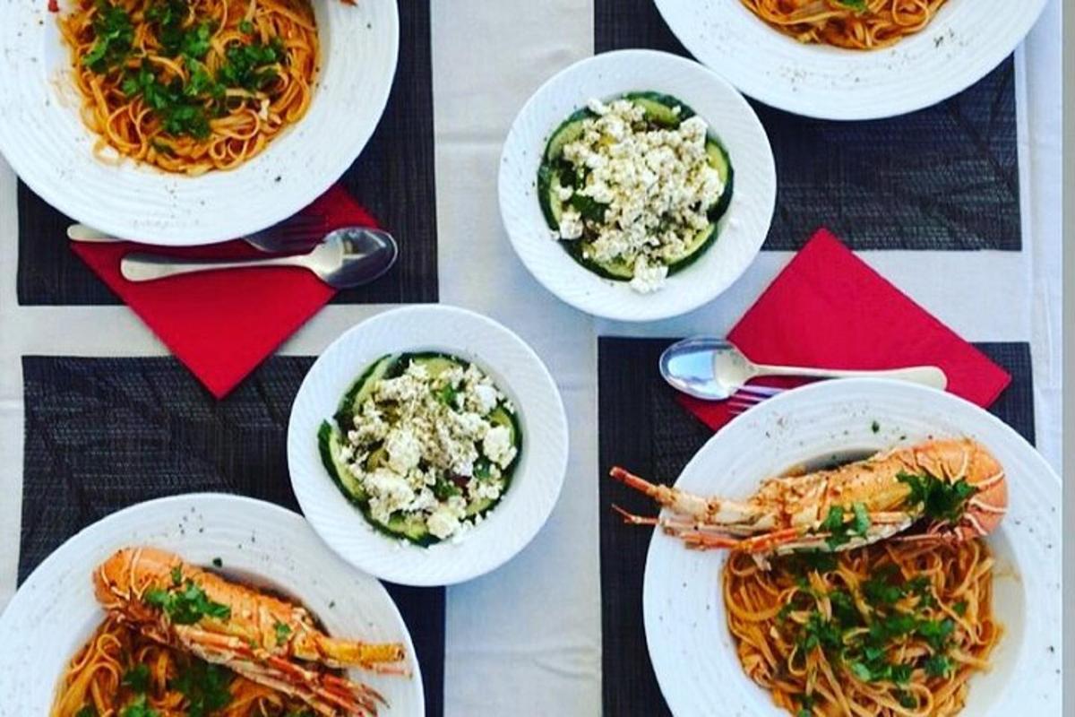 a table with plates of food and bowls of pasta