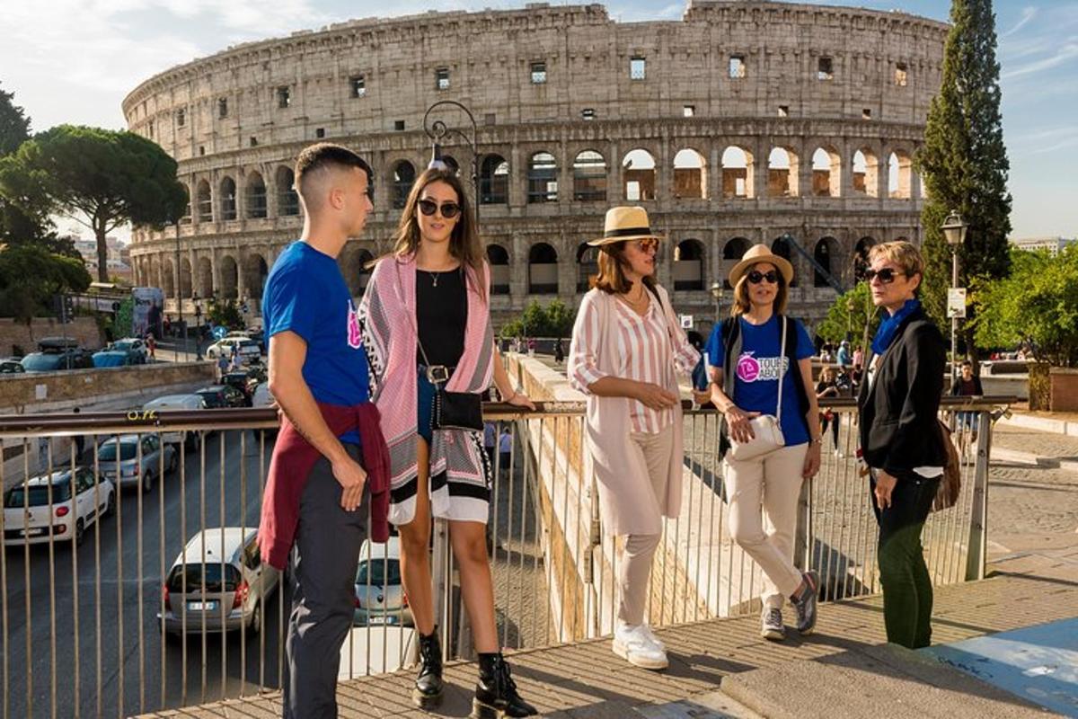un gruppo di persone in piedi davanti al Colosseo