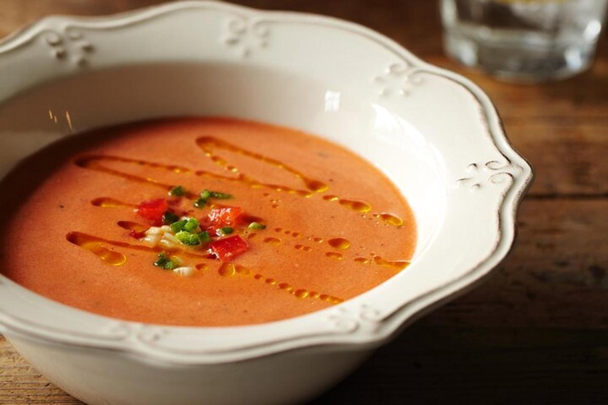 semangkuk sup tomato di atas meja kayu