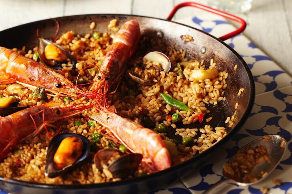 una padella piena di frutti di mare e riso su un tavolo