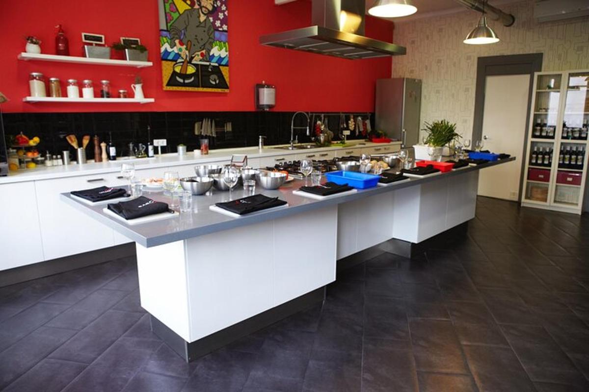 una cucina con pareti rosse e un piano di lavoro bianco
