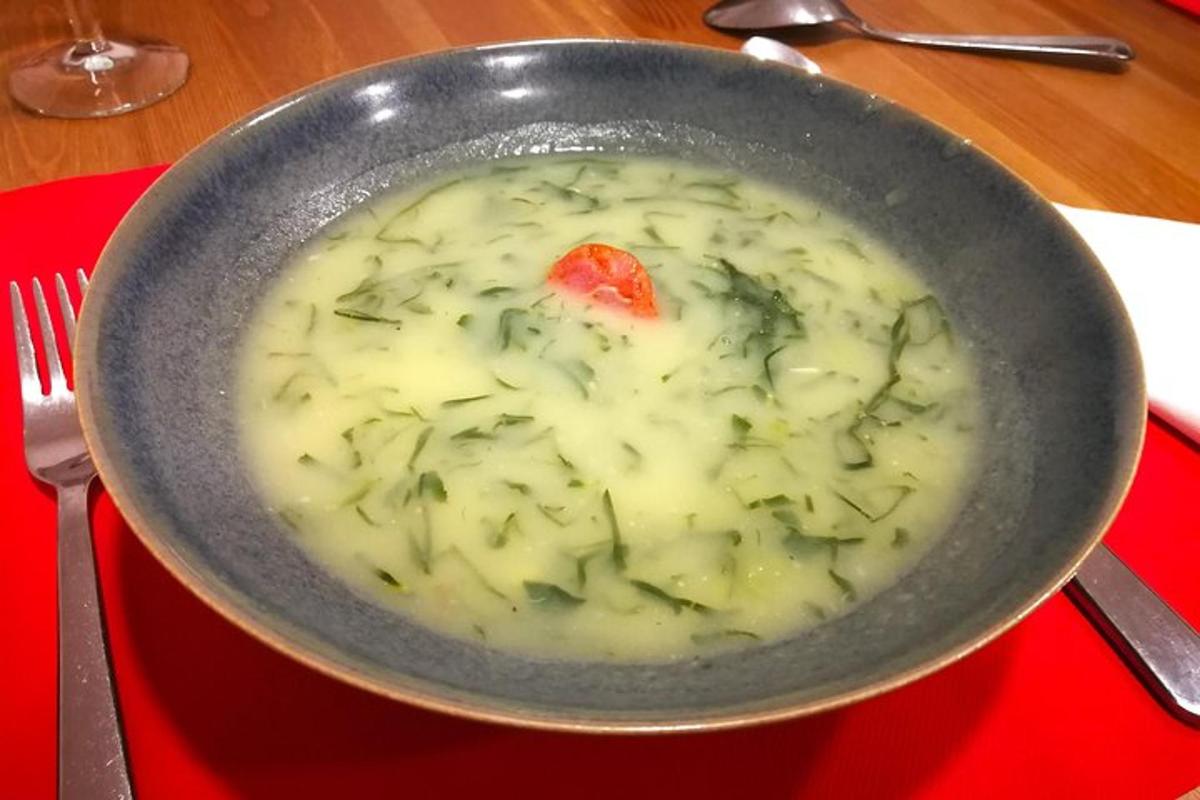 a bowl of soup on a red tray with a fork