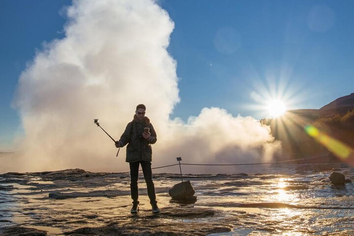 una persona in piedi davanti a un geyser