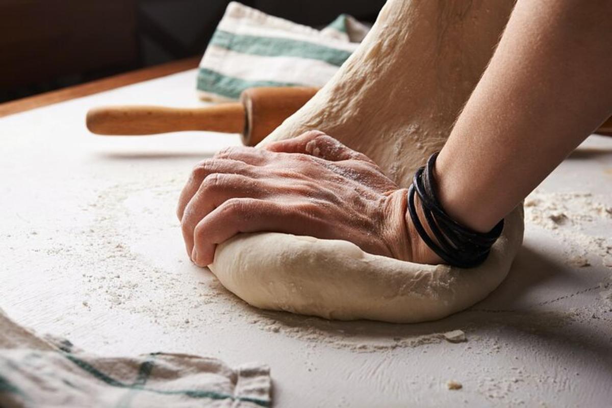a person kneading a piece of dough on a table