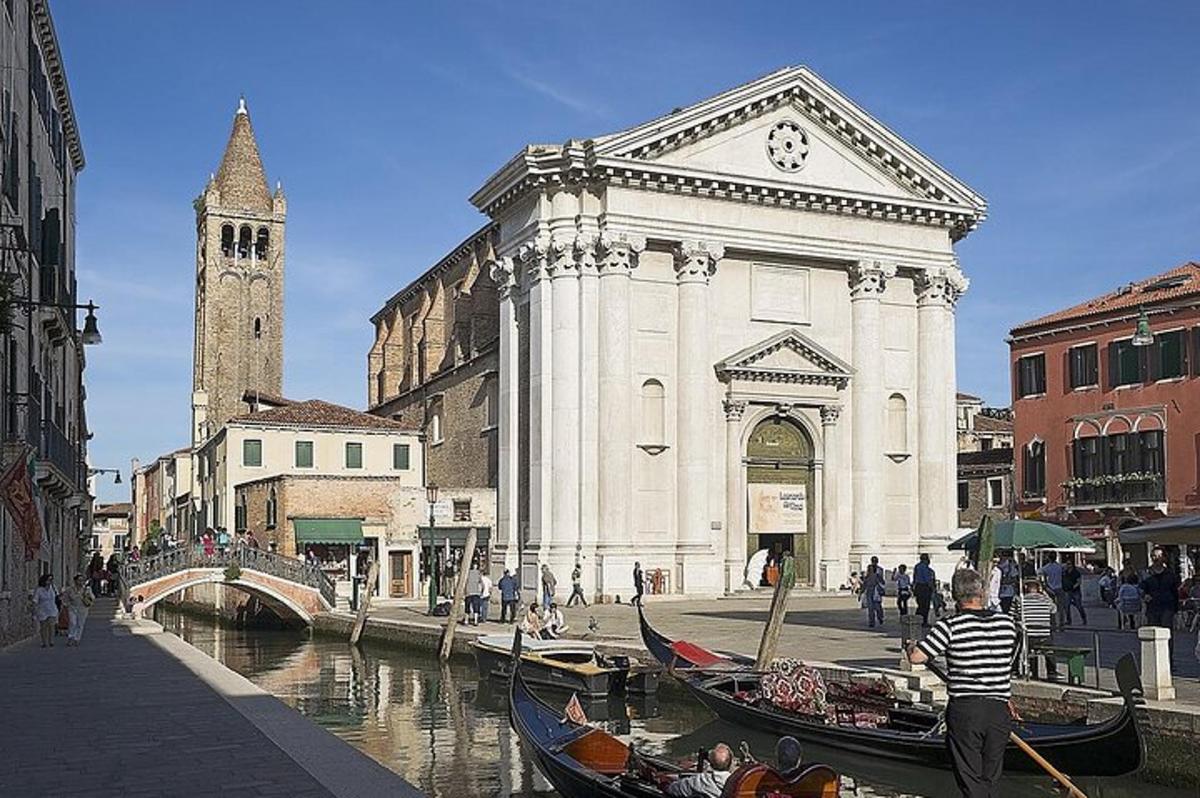 un gruppo di gondole in un canale di fronte a un edificio