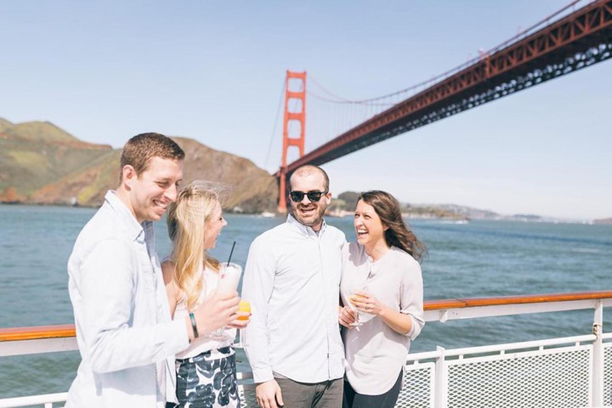 Hópur fólks stendur á báti fyrir framan Golden Gate brúna