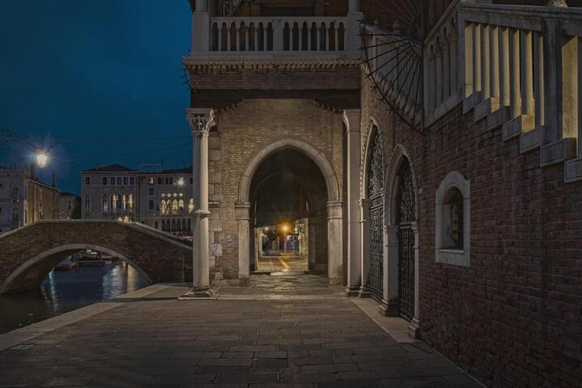 un edificio con un arco accanto a un fiume di notte