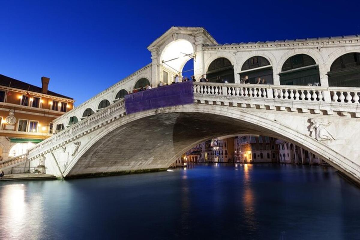 Un puente sobre un río en una ciudad por la noche.