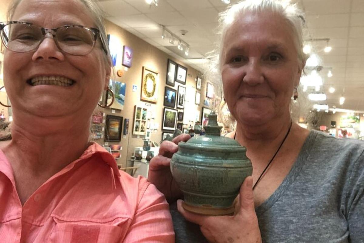 two older women holding a green pot in a store
