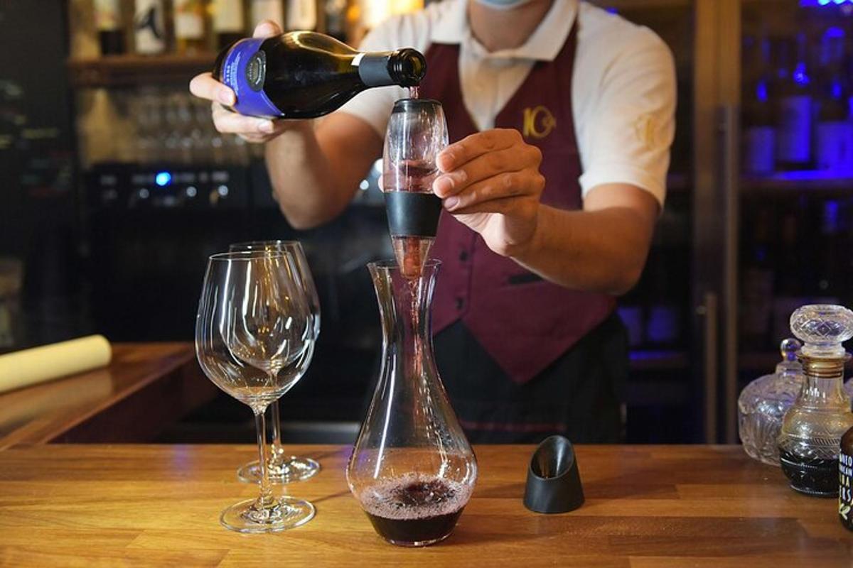 barþjónn hellir vínflösku í glas