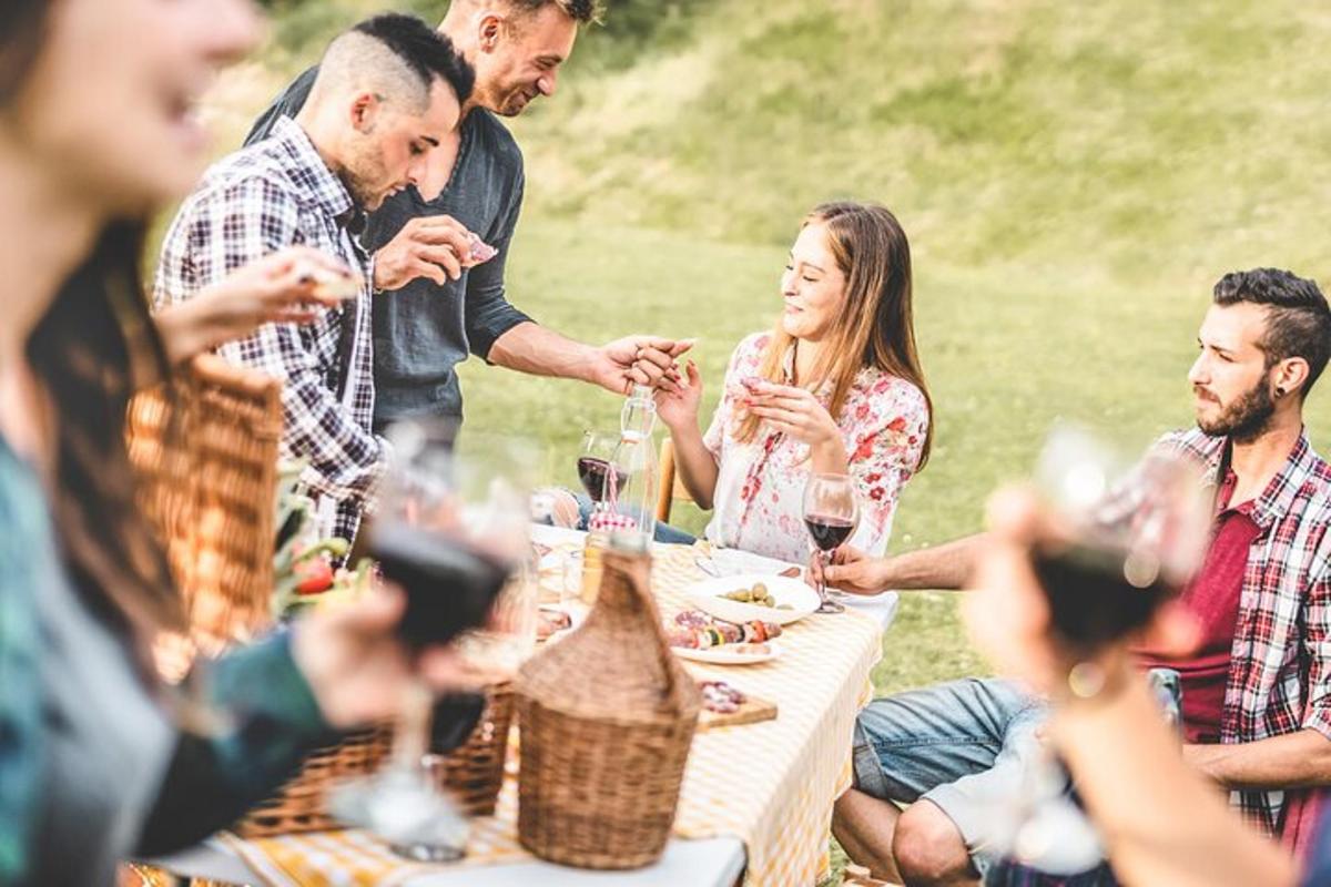 skupina lidí sedících kolem stolu s vinnými sklenicemi