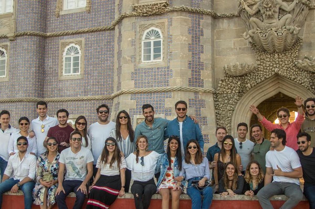 un grup de oameni care pozează în fața unui castel