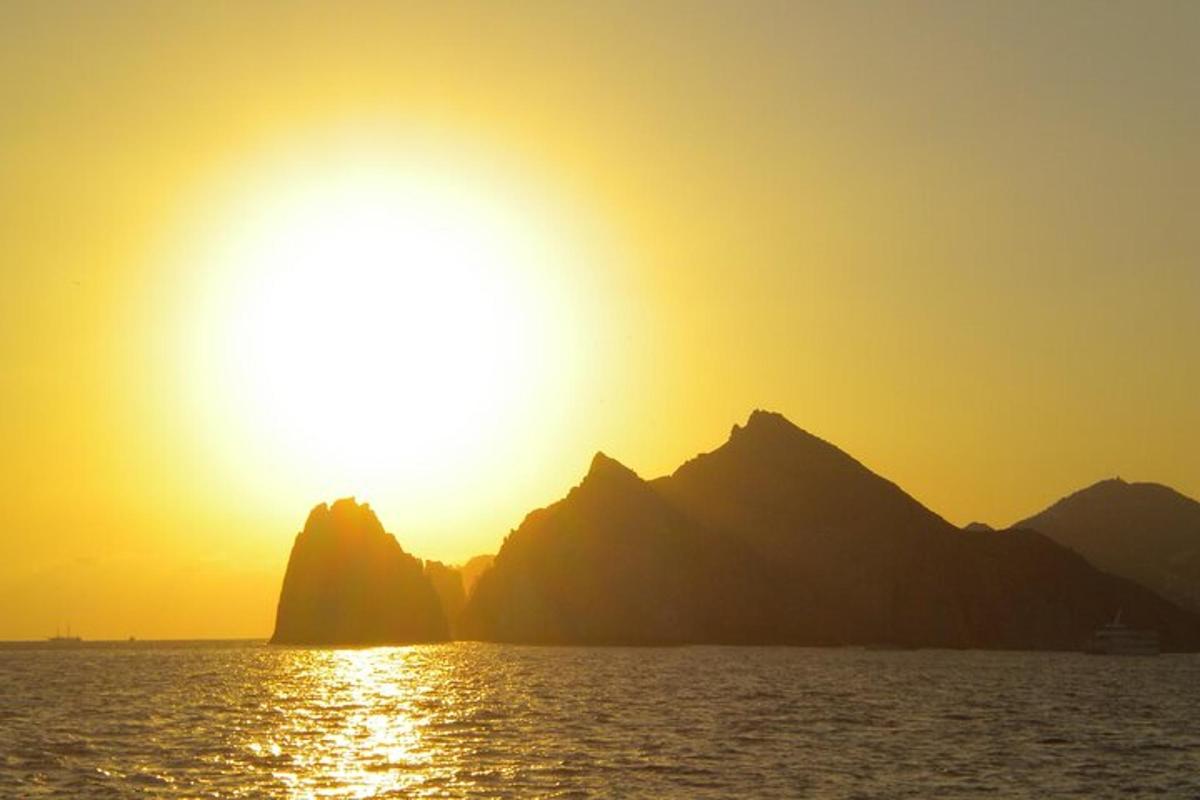 un tramonto sull'acqua con le montagne sullo sfondo